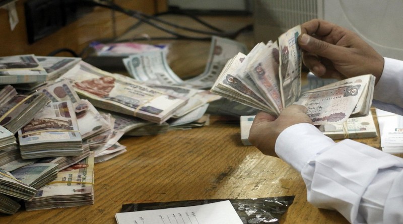 An employee counts money at a bank in Cairo